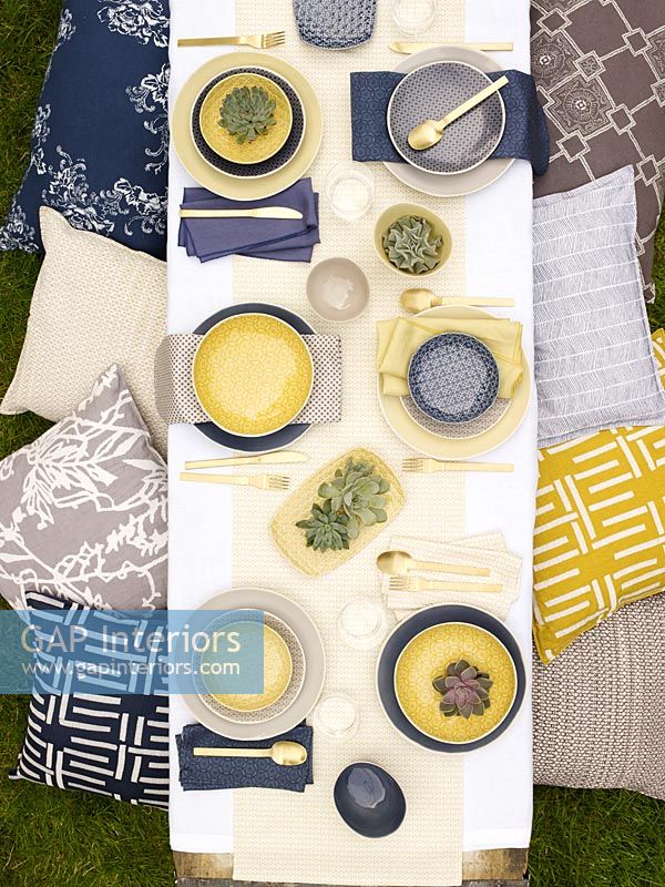Vue aérienne de la table à manger d'extérieur avec des accessoires bleus et jaunes