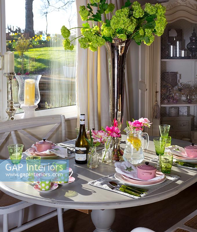 Salle à manger moderne aménagée pour le déjeuner avec des accessoires roses et verts