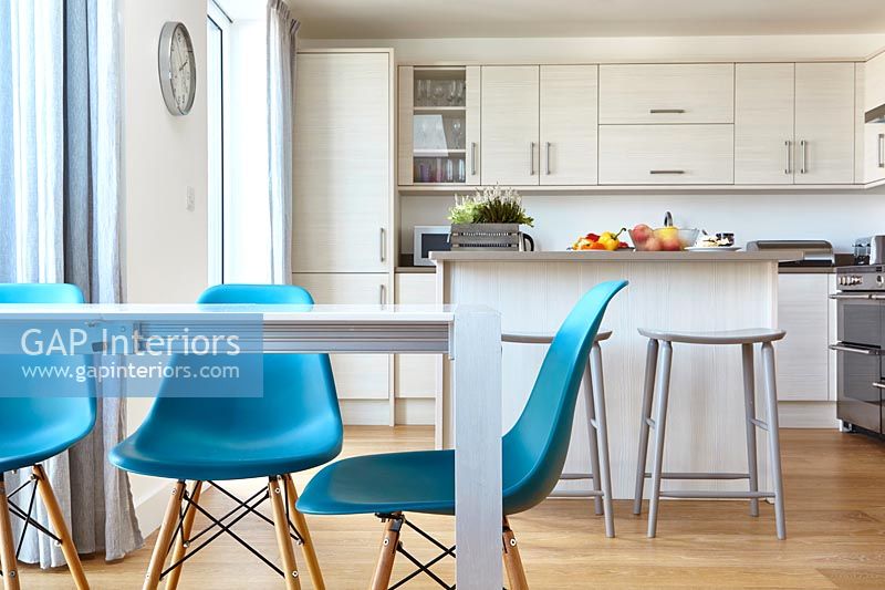 Chaises turquoise en cuisine moderne blanc avec plancher en bois