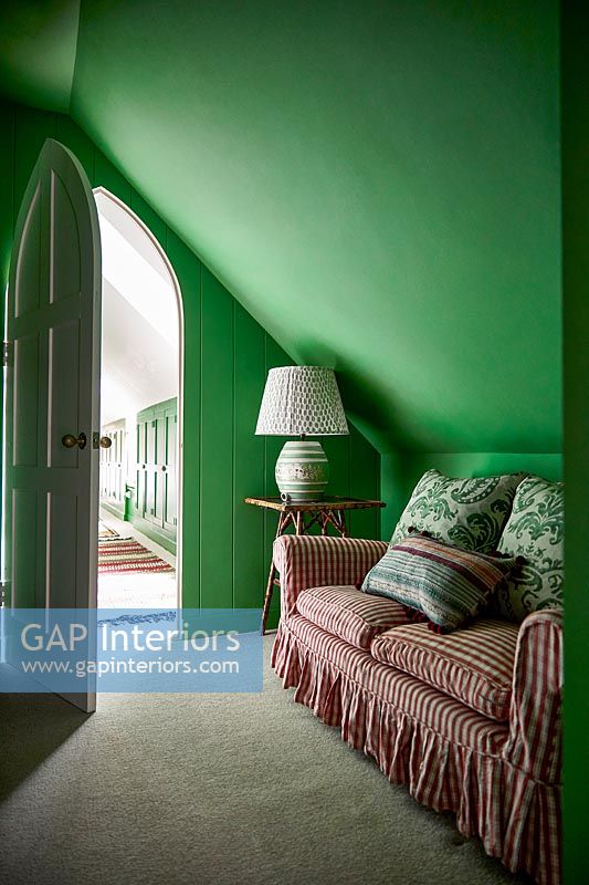 Canapé en vichy rouge dans une chambre peinte en vert