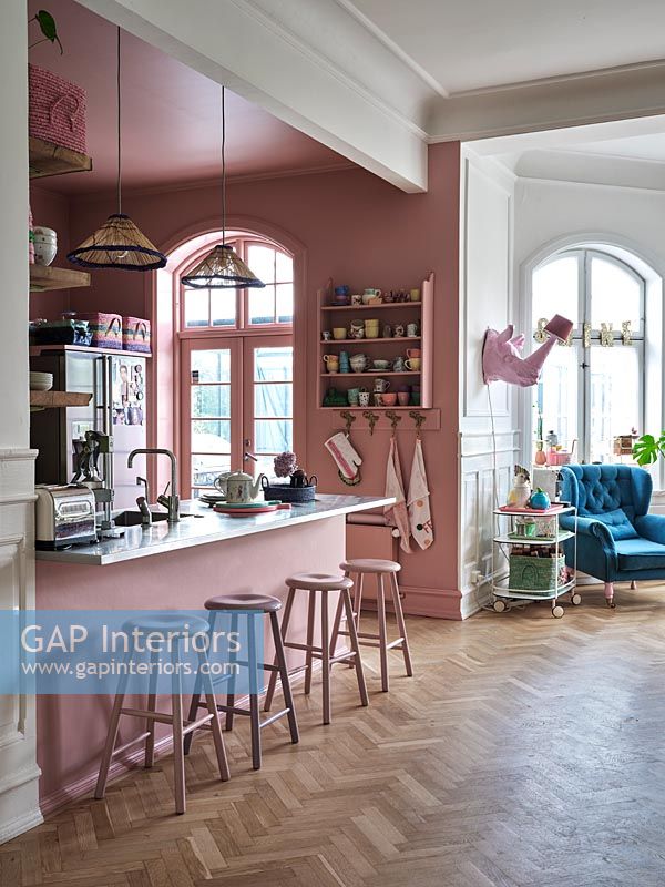 Cuisine moderne avec murs peints en rose et parquet