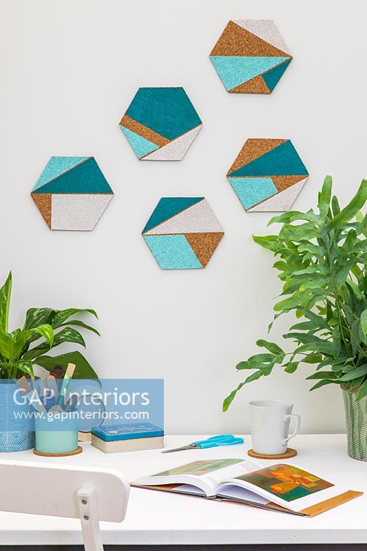 Formes de liège hexagonales avec des zones géométriques peintes utilisées pour les décorations murales au-dessus du bureau