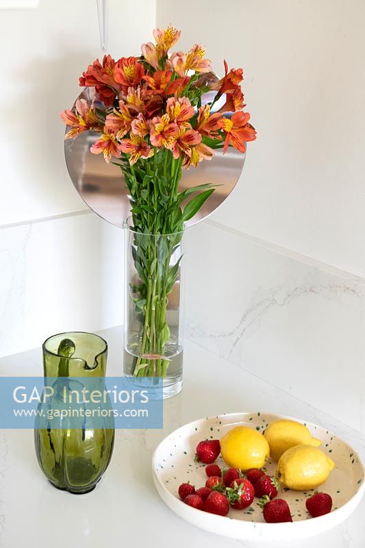Vase de fleurs et bol de fruits