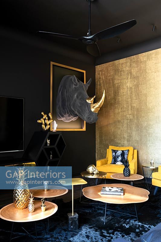 Salon éclectique avec murs peints en noir et tête de trophée Rhino en tissu sur le mur