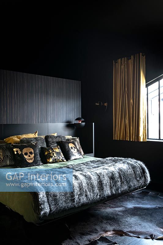 Chambre moderne avec murs noirs et rideaux dorés