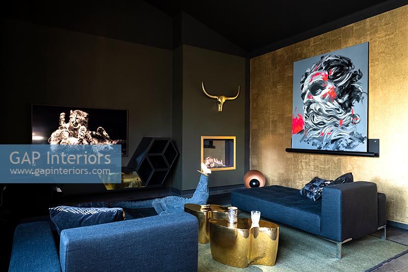 Chambre moderne noire et or avec des œuvres d'art colorées et un grand coin salon