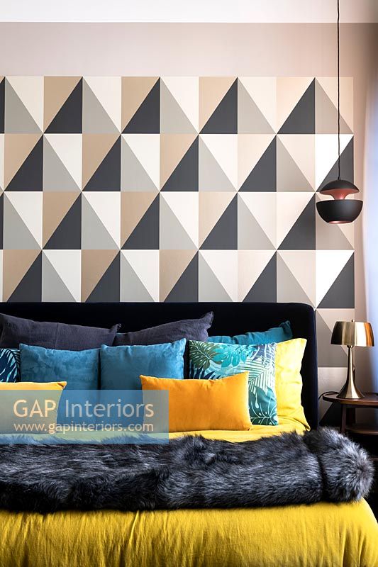 Chambre moderne avec literie colorée et mur à motifs
