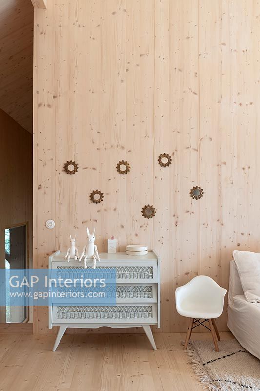 Commode gris pâle dans la chambre d'enfants moderne revêtue de bois
