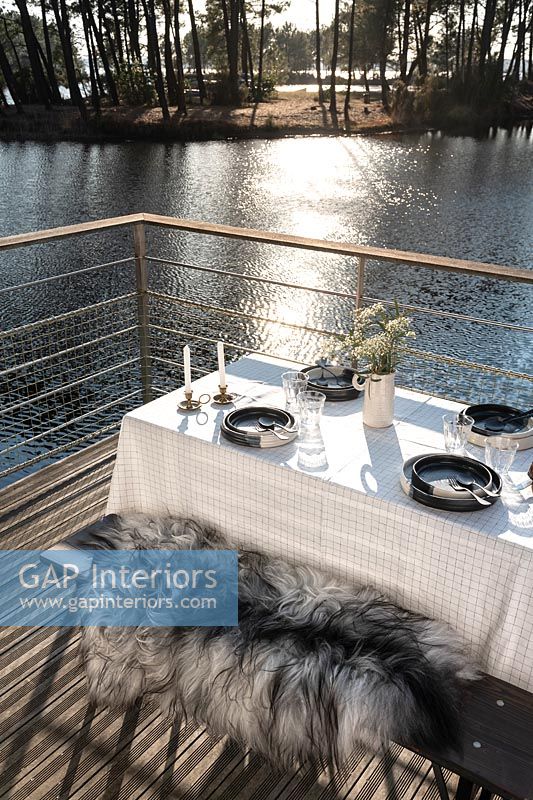 Table à manger extérieure sur balcon au bord du lac