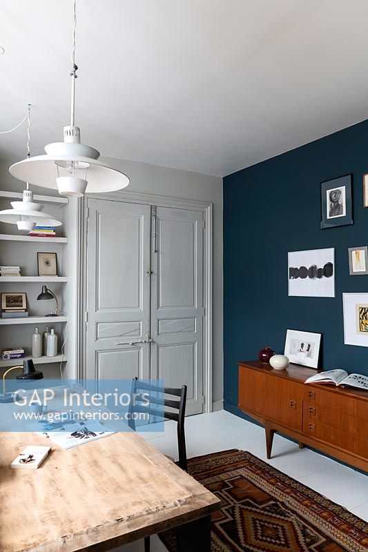 Mobilier vintage et mur peint en bleu dans une étude moderne