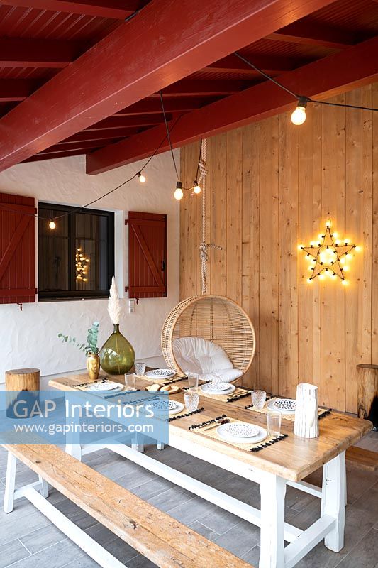 Salle à manger extérieure moderne avec chaise pivotante et lumière en forme d'étoile