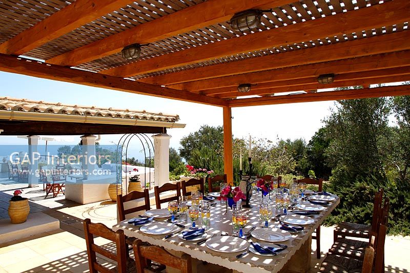 Grande table à manger sous terrasse couverte prévue pour le déjeuner en été