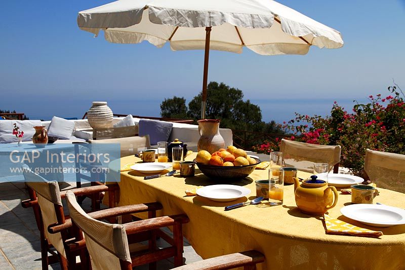 Coin repas extérieur sur terrasse avec vue sur la côte
