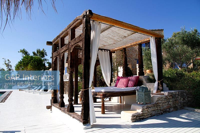 Pergola décorative avec grand lit sur terrasse extérieure