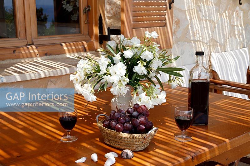 Arrangement de fleurs, raisins et vin sur table à manger extérieure