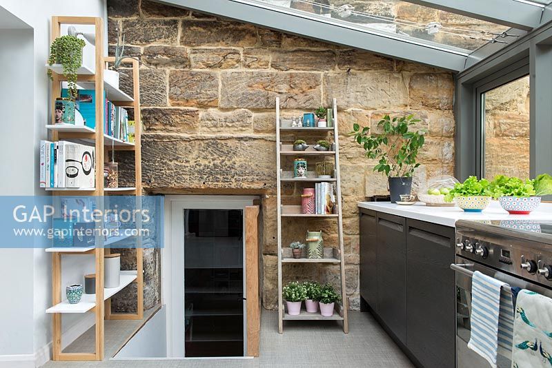 Extension de cuisine moderne avec vue sur la maison en pierre et la porte
