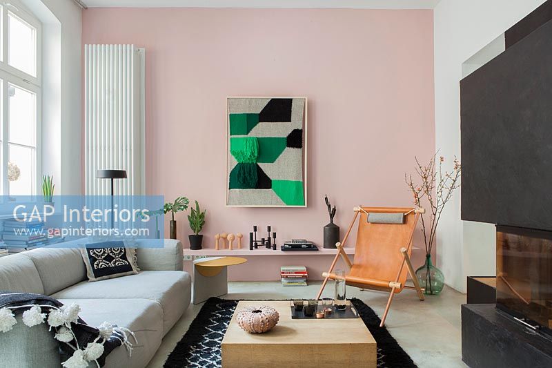Mur caractéristique peint en rose pâle avec radiateur vertical dans un salon contemporain