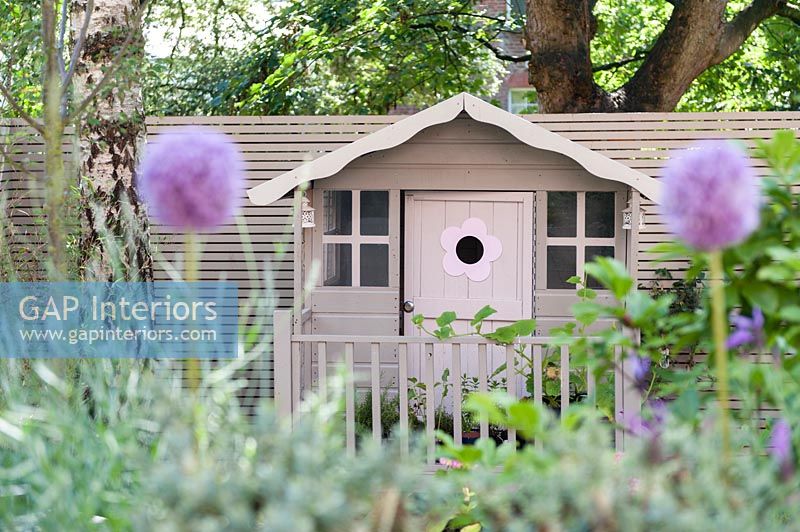 Playhouse peint en rose dans un jardin moderne
