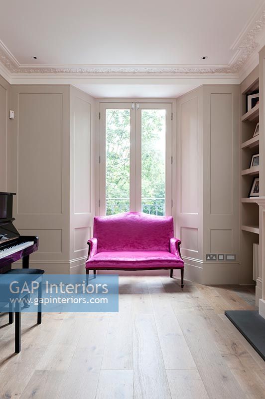 Canapé deux places rose vif dans le salon classique