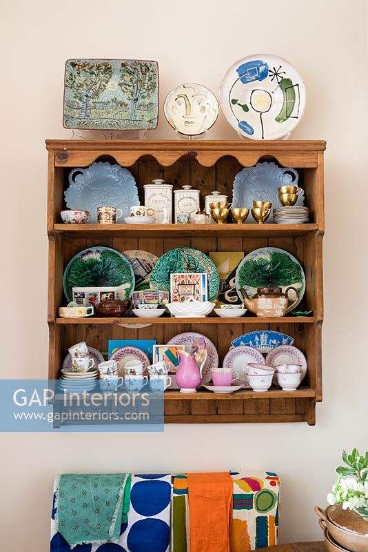 Assiettes décoratives sur des étagères en bois dans une petite cuisine éclectique