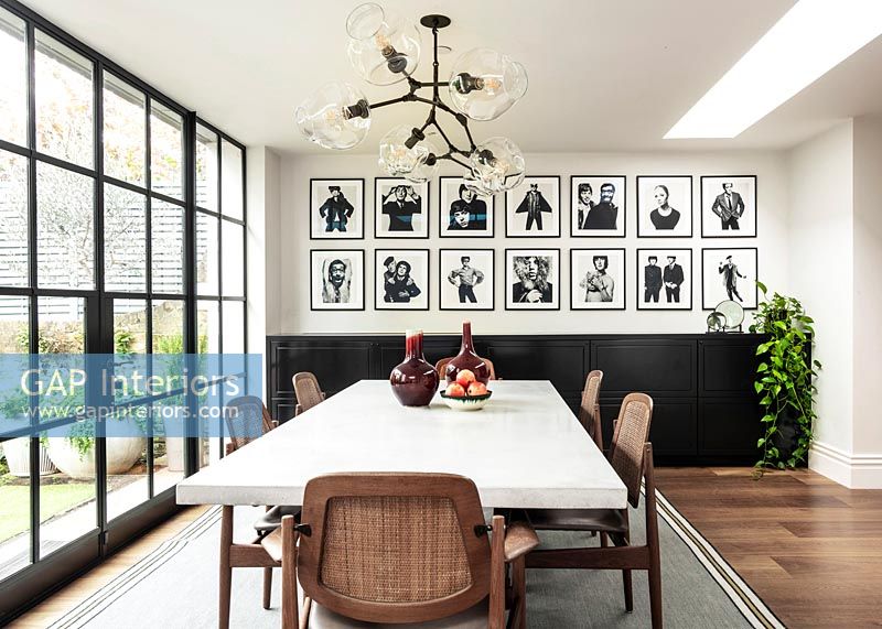 Salle à manger moderne avec un mur de photographies en noir et blanc
