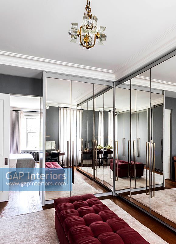 Grandes armoires encastrées en miroir dans un dressing de style rétro