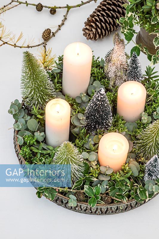 Arrangement de l'Avent avec bougies blanches, faux sapins de Noël miniatures