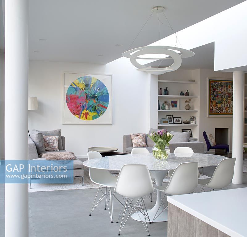 Table à manger circulaire blanche et chaises dans un espace de vie moderne et ouvert