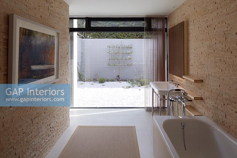 Salle de bain contemporaine avec mur vitré à une extrémité