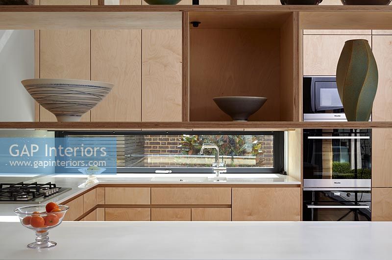 Vue de la cuisine moderne à travers des étagères flottantes
