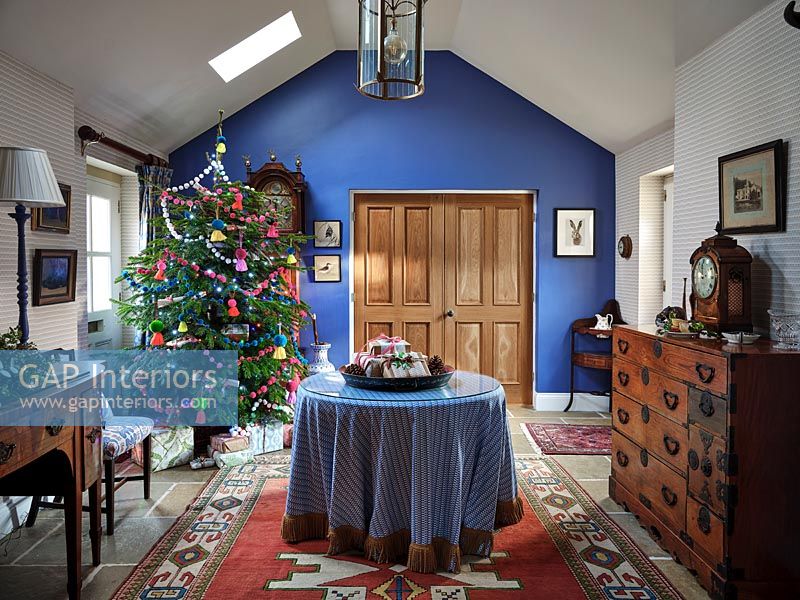 Couloir peint en bleu avec table centrale et arbre de Noël