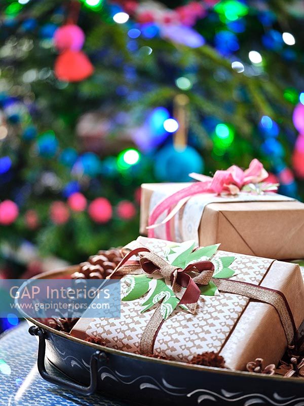 Cadeaux de Noël emballés sur plateau avec des pommes de pin