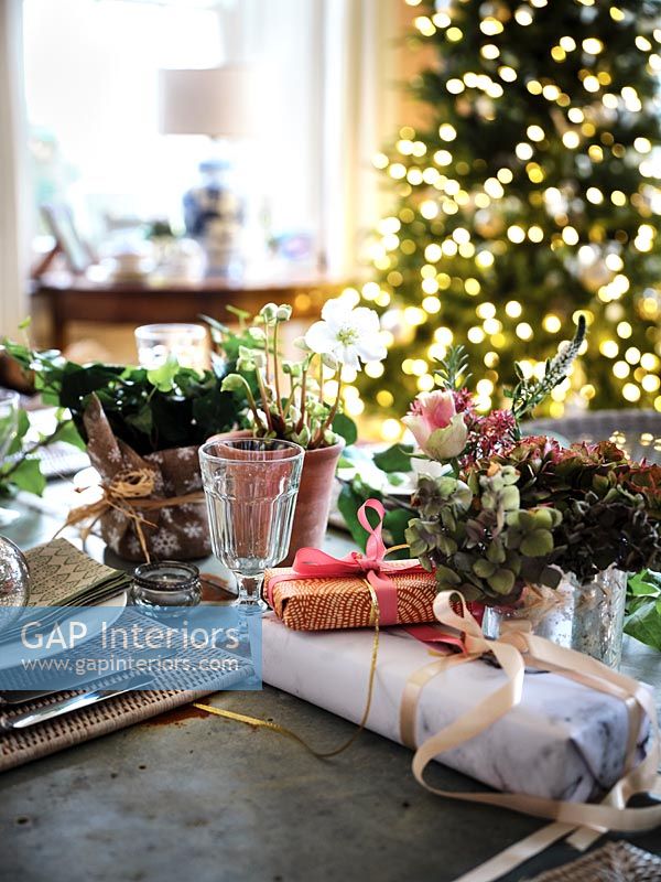 Cadeaux de Noël sur table à manger avec arbre en arrière-plan