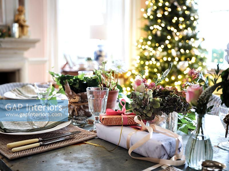 Cadeaux de Noël sur table à manger avec arbre en arrière-plan