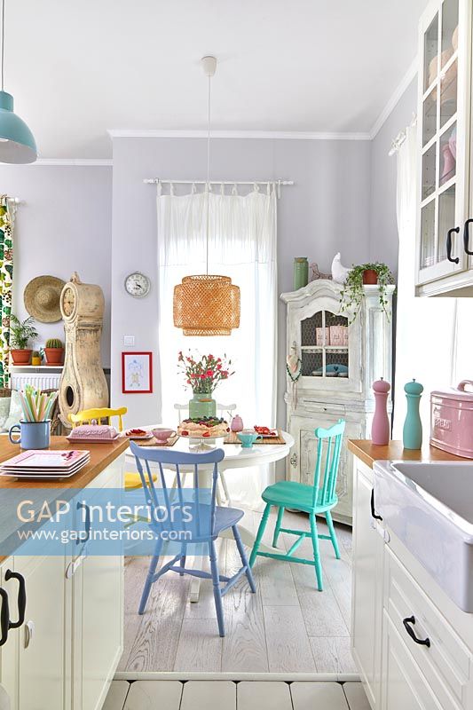 Cuisine-salle à manger moderne avec des accessoires pastel dans un petit espace de vie ouvert
