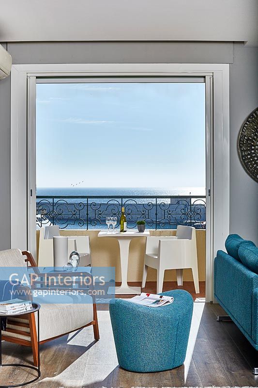 Salon moderne avec vue sur la mer par des portes-fenêtres ouvertes