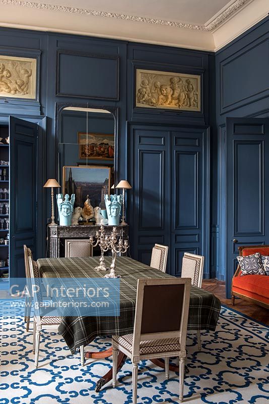 Murs lambrissés peints en bleu foncé dans la salle à manger de style classique