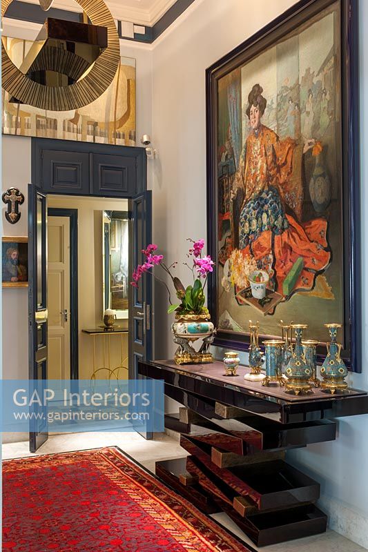 Grande peinture classique et table console inhabituelle dans le couloir