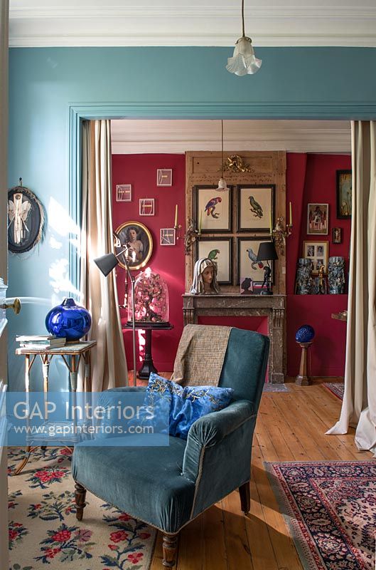 Fauteuil bleu dans un salon de style classique avec des murs peints de couleurs vives