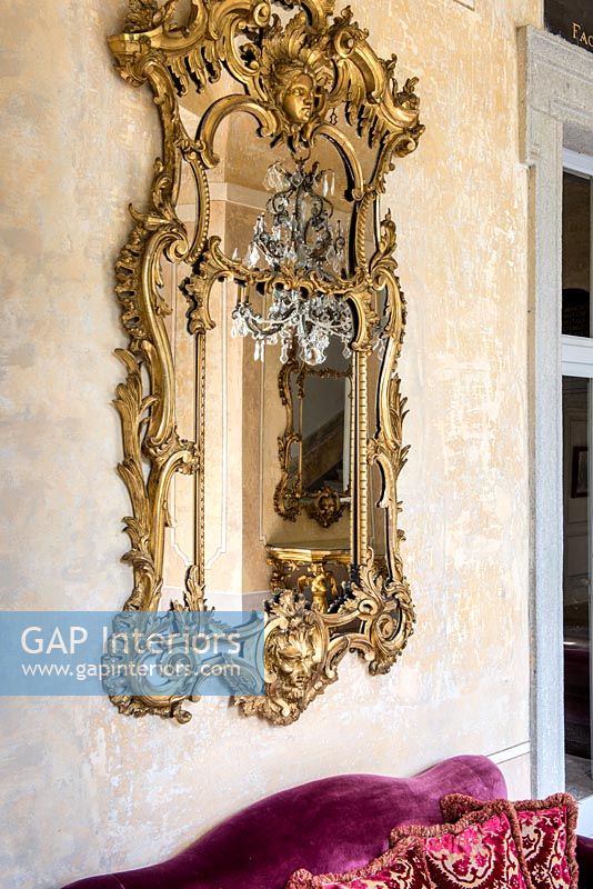 Détail de miroir doré classique sur mur de plâtre nu