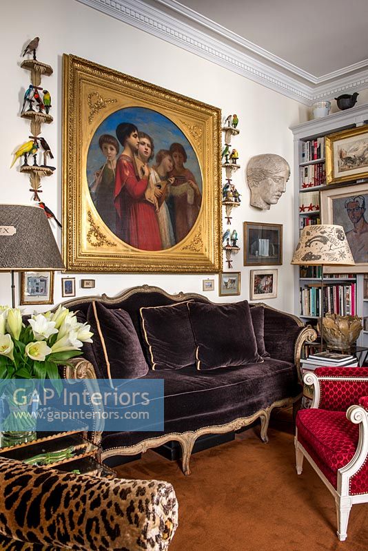 Grande peinture classique au-dessus d'un canapé en velours marron dans un salon éclectique