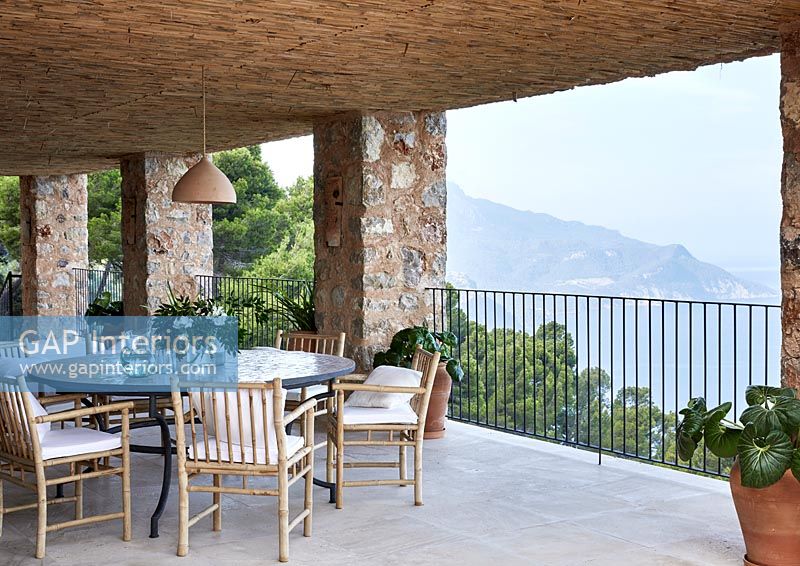 Table ronde et chaises sur balcon avec vue mer