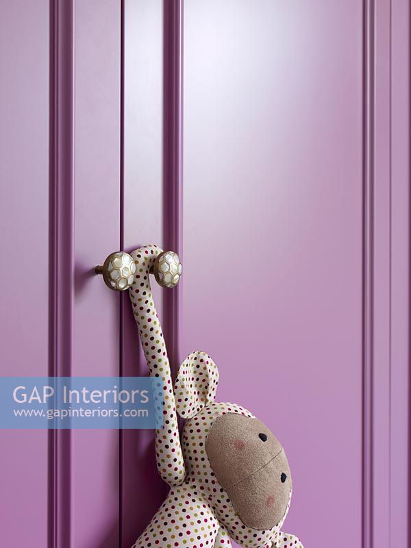 Jouet suspendu à des portes d'armoire peintes en violet