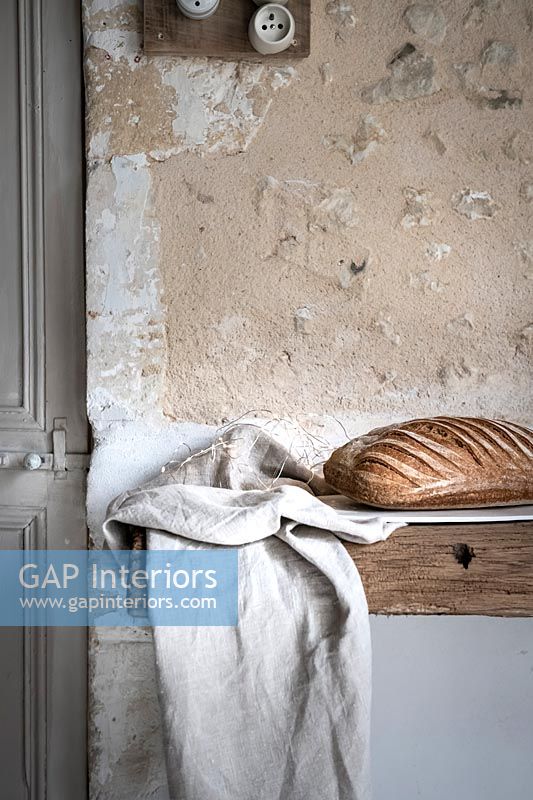 Détail de la miche de pain sur table rustique à côté de mur texturé