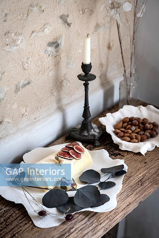 Fromage de chèvre, figues et noix sur table rustique à côté de mur texturé