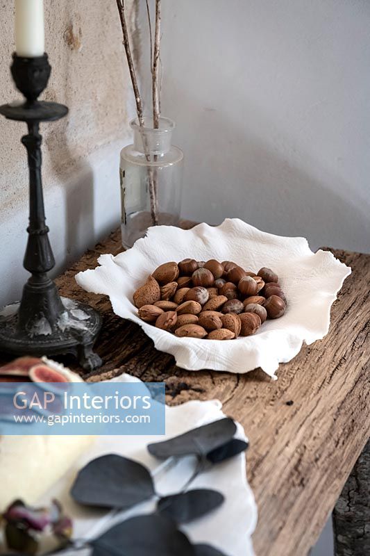 Bol en céramique décorative de noix récoltées dans leur coquille sur table rustique