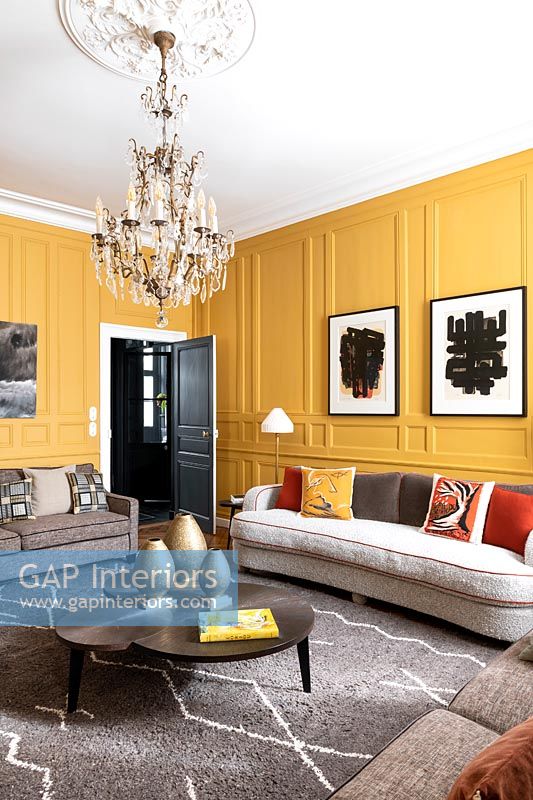 Salon moderne avec murs lambrissés peints en jaune