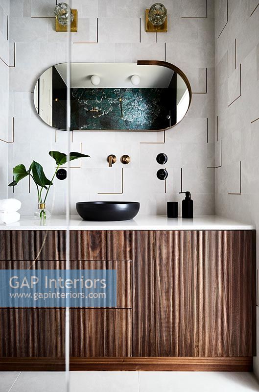 Salle de bains moderne avec carrelage texturé sur le mur et armoire en bois