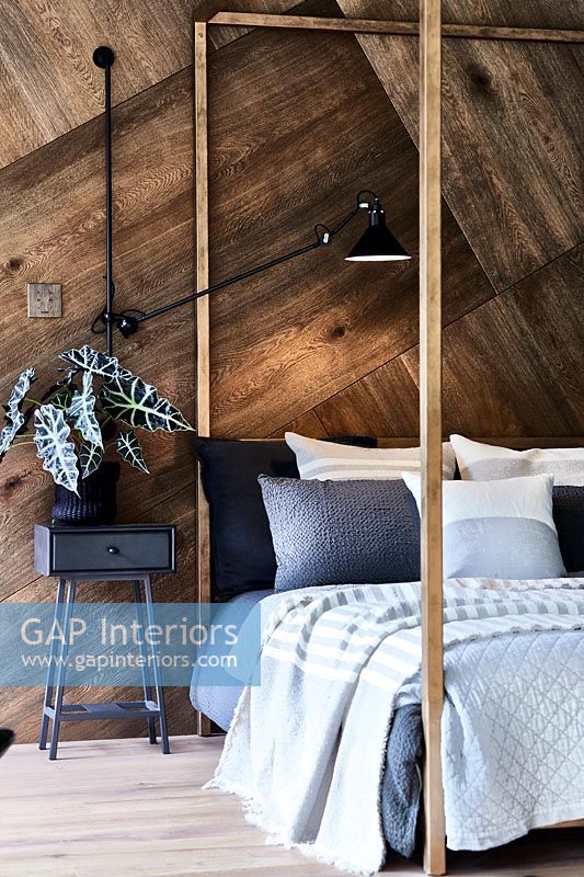 Chambre moderne avec mur en bois et lit à baldaquin