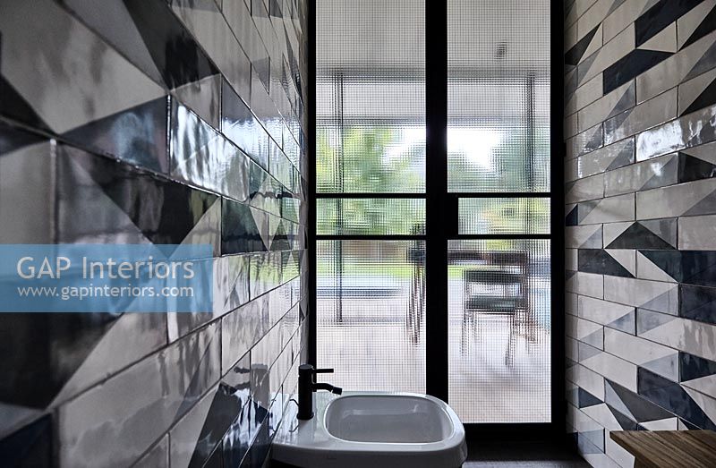 Vue dans la salle de bains moderne avec carrelage à motifs sur le mur